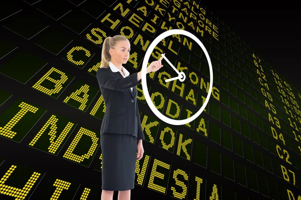 Businesswoman pointing to white clock