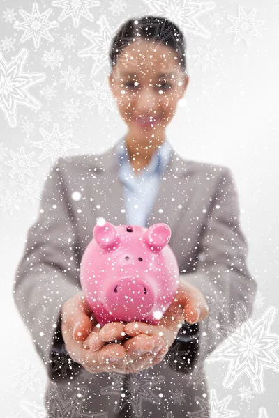 Happy businesswoman showing a piggy bank