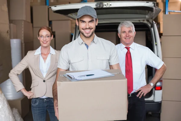 Warehouse managers and delivery driver smiling