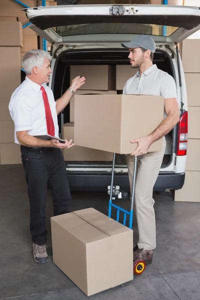 Warehouse manager and delivery driver talking
