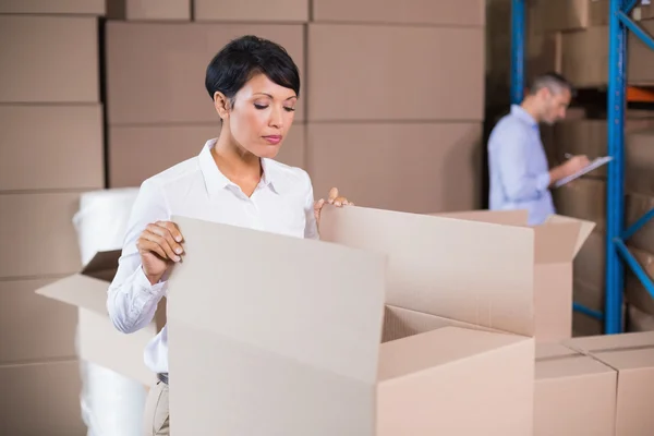 Warehouse manager looking in box