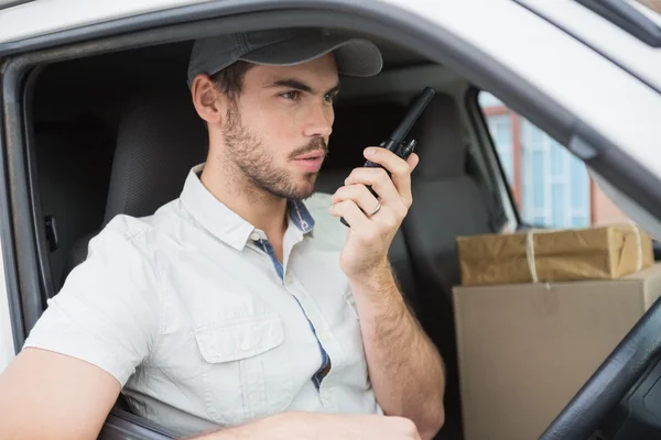 Delivery driver talking on walkie talkie