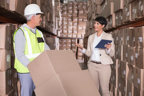 Warehouse worker moving boxes on trolley