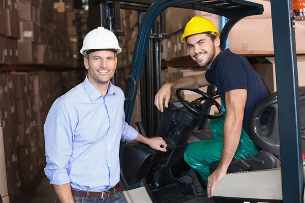 Warehouse manager with forklift driver