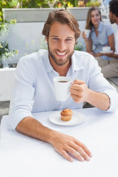 Happy man having coffee and muffin