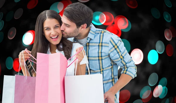 Composite image of happy couple with shopping bags