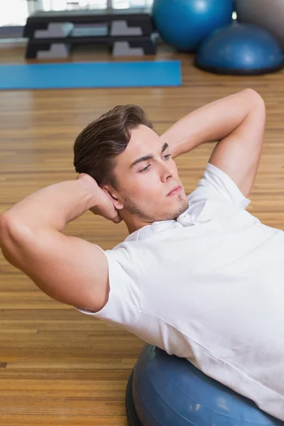 Man doing sit up on exercise ball