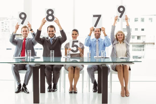 Interview panel holding score cards in office