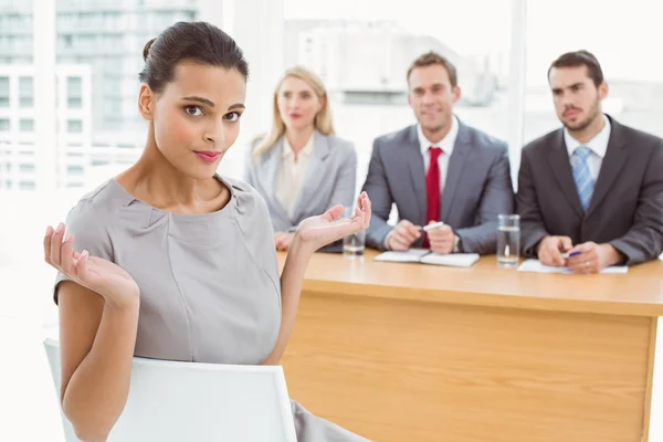 Woman sitting in front of corporate personnel officers