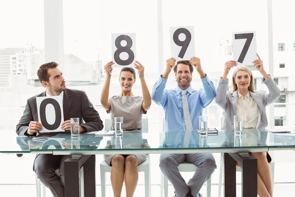 Interview panel holding score cards in office