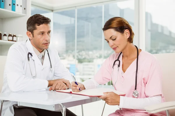 Doctors discussing reports at medical office