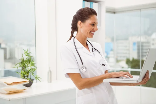 Female doctor using laptop in medical office