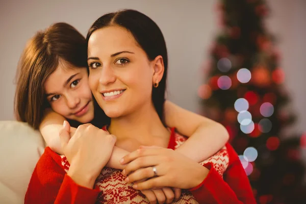 Festive mother and daughter smiling at each other