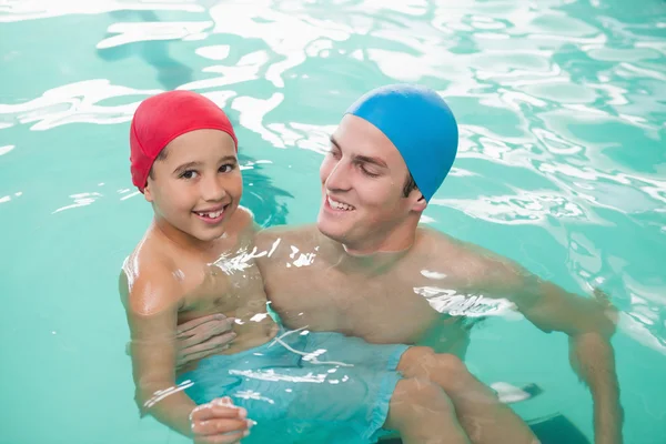Boy learning to swim with coach