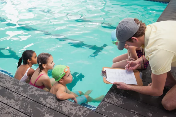 Cute swimming class listening to coach