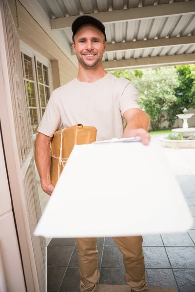 Delivery man showing clipboard to sign to customer