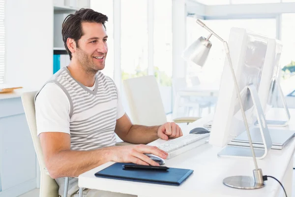 Smiling casual young man using computer