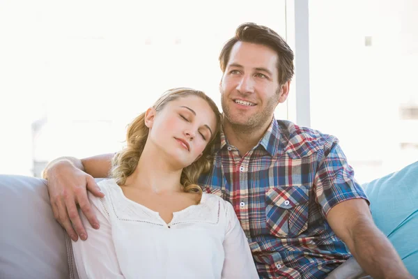 Girlfriend lying on the shoulder of her boyfriend on the sofa