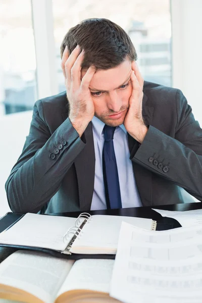 Stressed businessman with head in hands