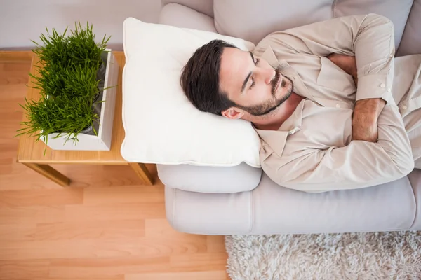 Man sleeping on the couch with arms crossed