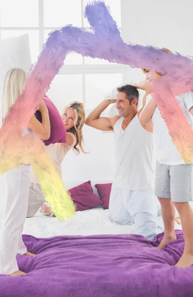 Composite image of family having fun with pillows