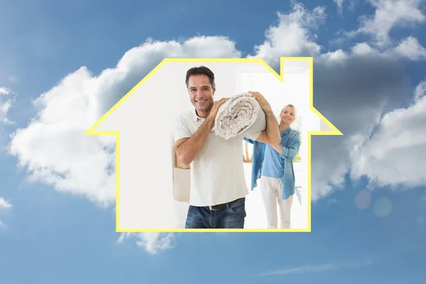 Smiling couple carrying rolled rug