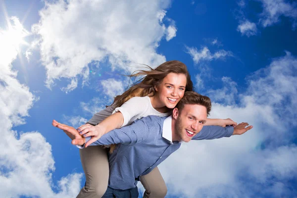 Smiling young man carrying woman