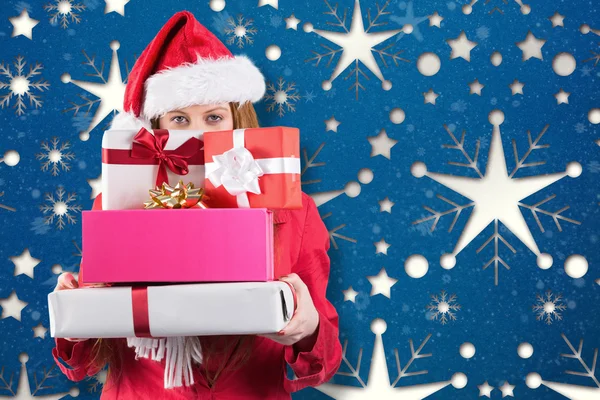 Festive redhead holding pile of gifts