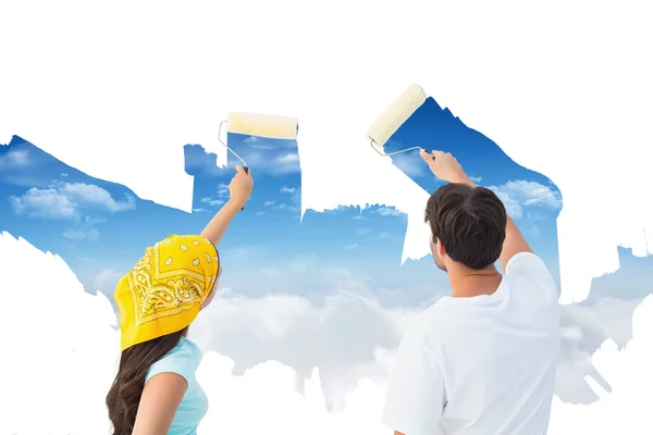 Young couple painting together sky