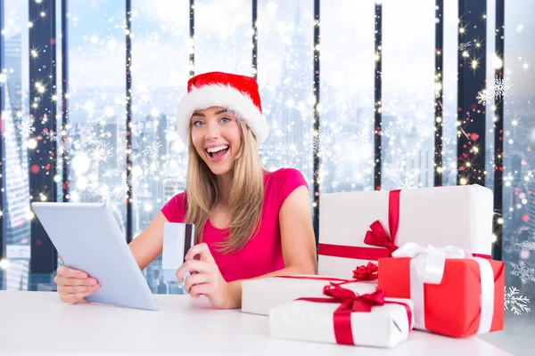 Festive blonde shopping online with tablet