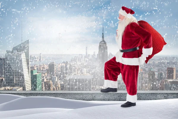 Santa standing on snowy ledge