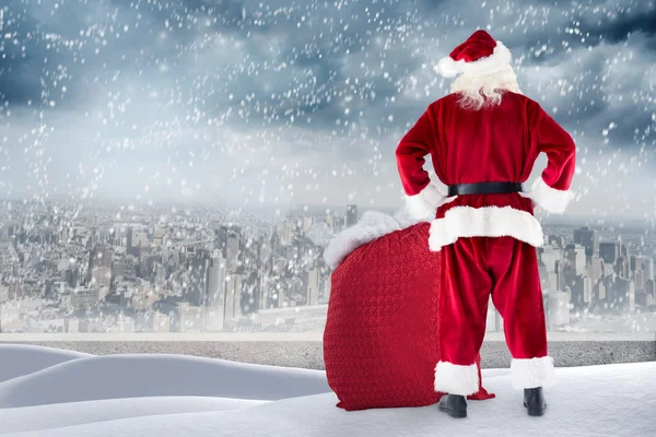Santa standing on snowy ledge