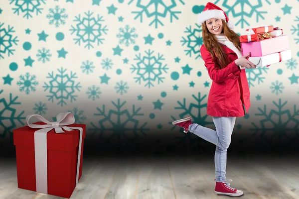 Festive redhead holding pile of gifts