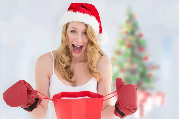 Shocked blonde opening a shopping bag