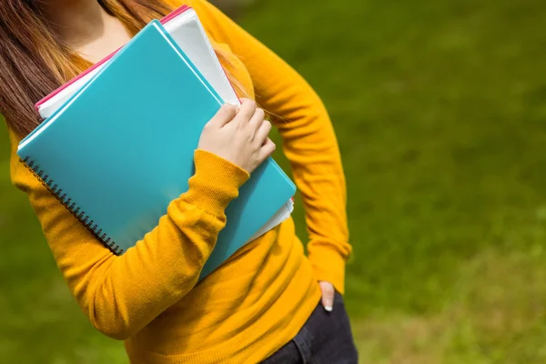 Female student with books in park