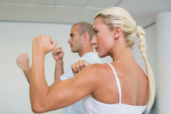Sporty couple clenching fists at fitness studio