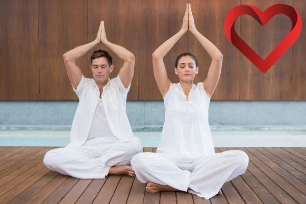 Attractive couple in white sitting in lotus pose