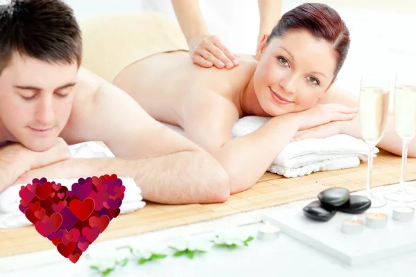 Composite image of attractive couple receiving a back massage