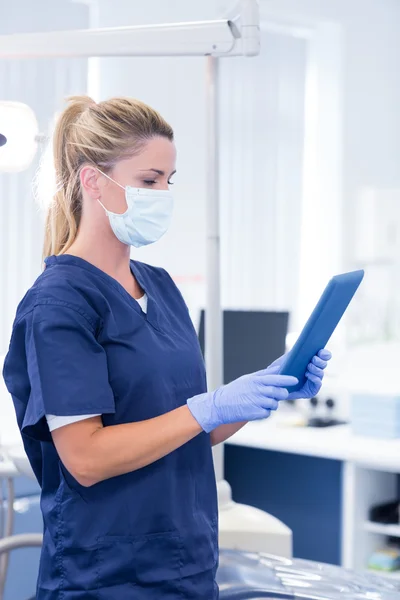 Dentist in mask and blue scrubs