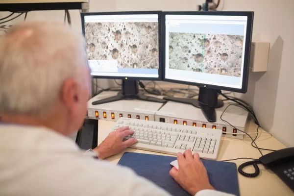 Biochemist looking at microscopic images on computer