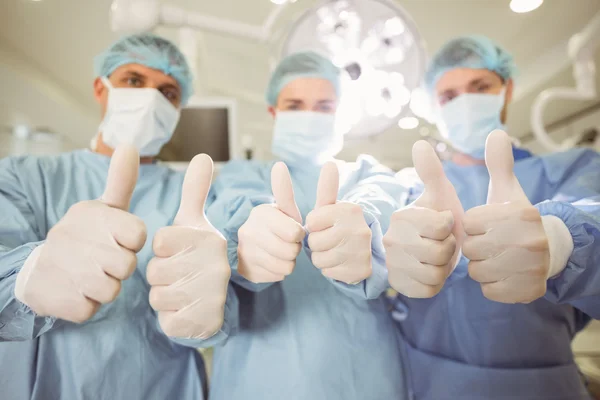Team of surgeons showing thumbs up