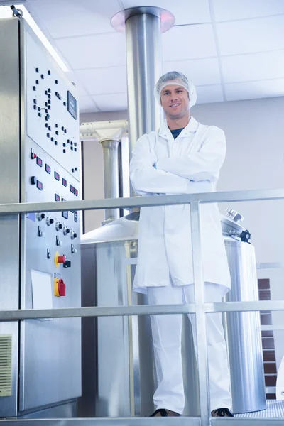 Smiling scientist standing with arms crossed