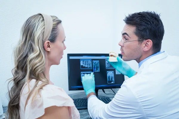 Dentist showing woman prosthesis teeth