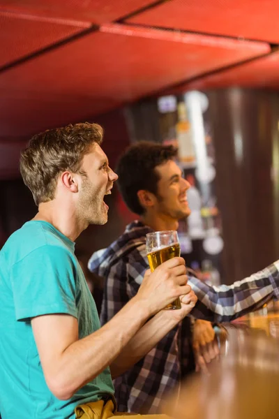 Happy friends sitting and drinking beer