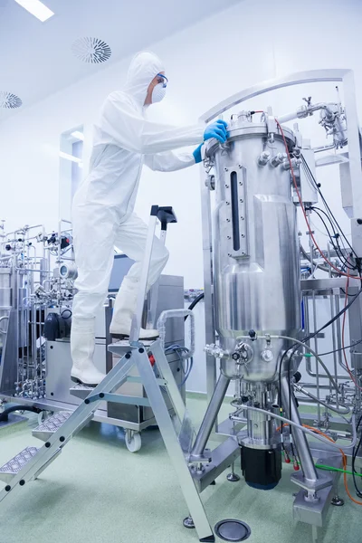 Scientist in protective suit standing on ladder