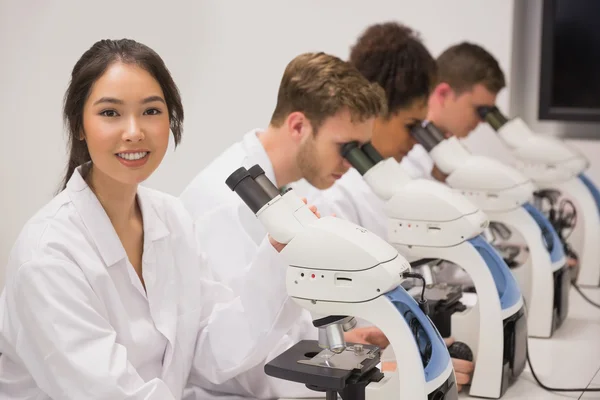 Medical students working with microscope