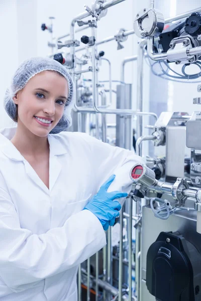 Smiling scientist leaning against gauge