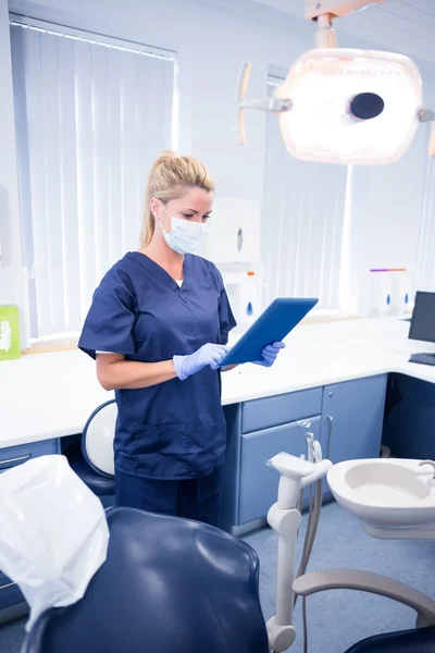 Dentist in mask and blue scrubs