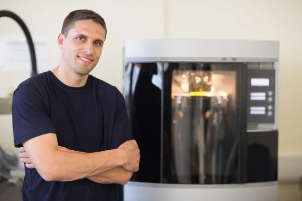 Engineering student smiling beside 3d printer