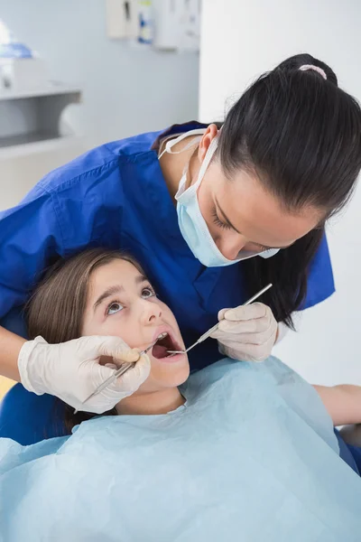 Dentist using dental explorer and angled mirror